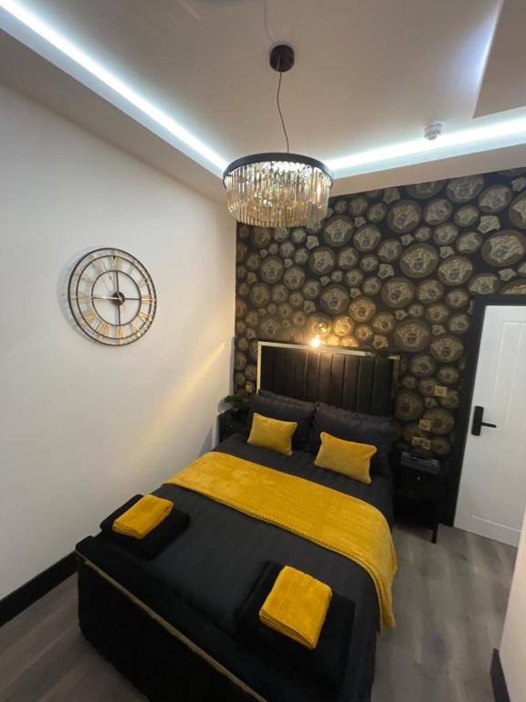 a bedroom with a bed and a clock on the wall at RESIDENCY LUXURY SEAFRONT HOTEL in Blackpool