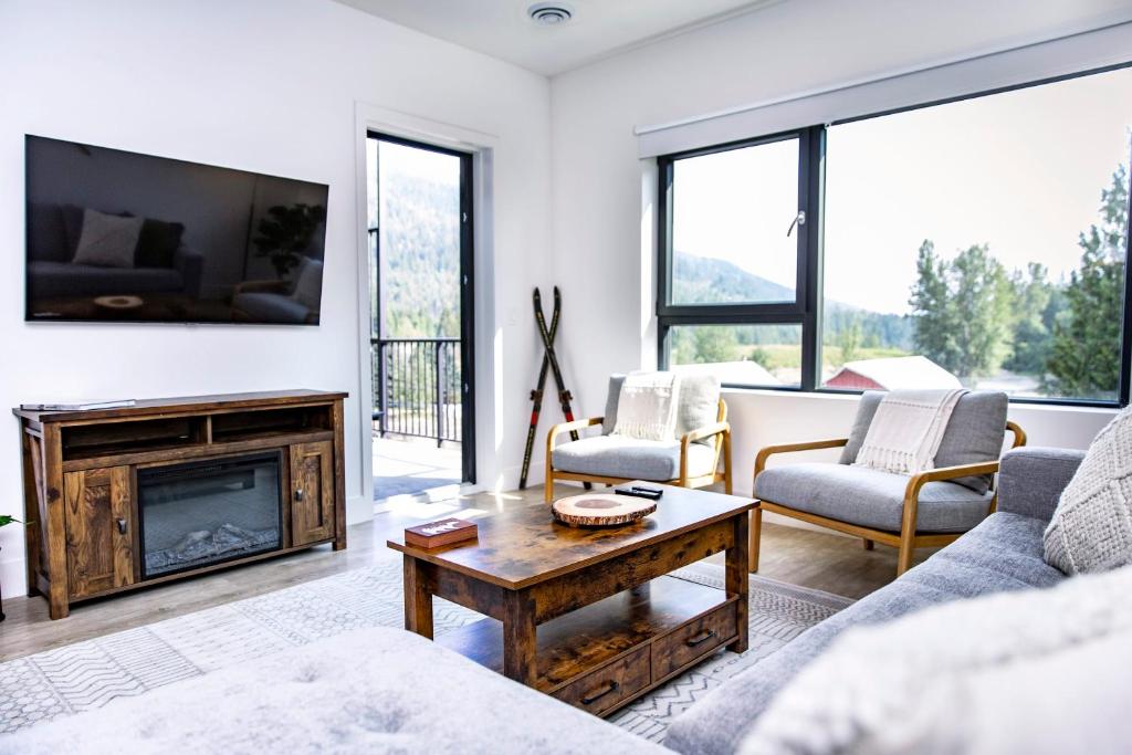 a living room with a fireplace and a tv at Revy's Stellar Retreat in Revelstoke