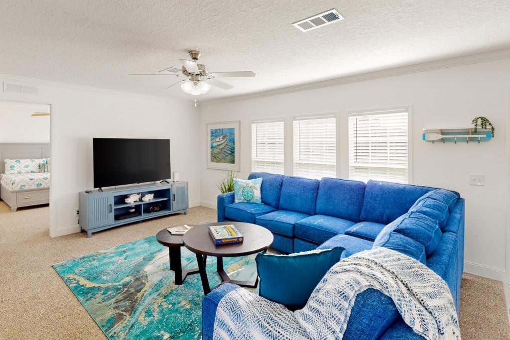 un soggiorno con divano blu e TV di Long Lake House a Okeechobee