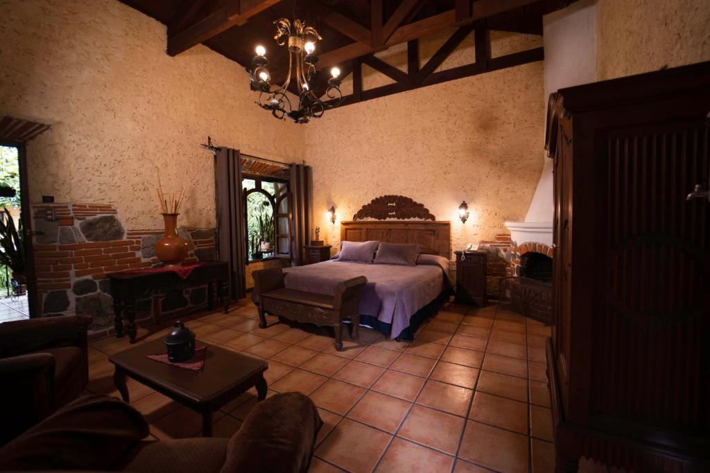 1 dormitorio grande con 1 cama y chimenea en Hotel Real Plaza, en Antigua Guatemala