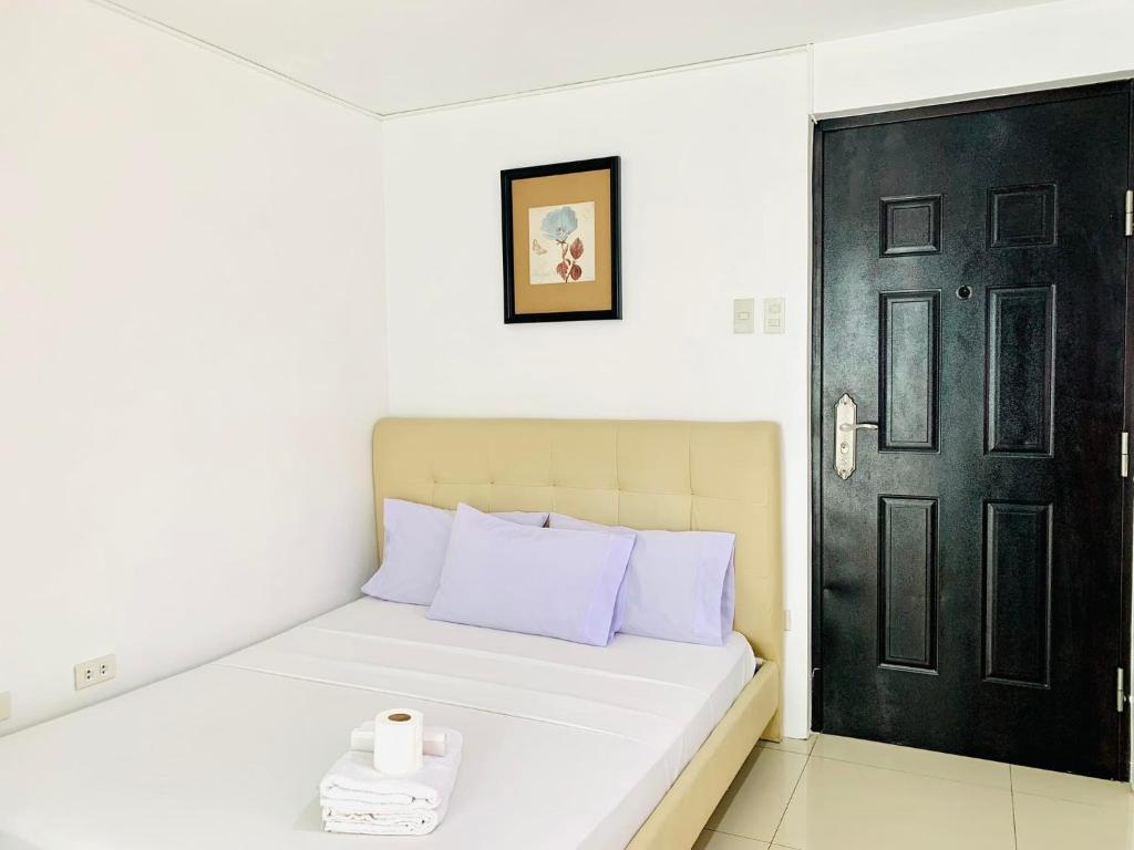 a bedroom with a bed with a black door at Crosswinds Hotel in Manila