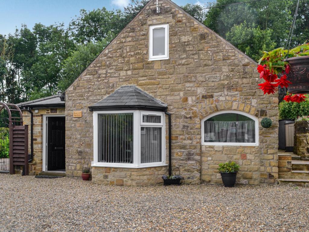 a brick building with a window and a door at Stoney Wall-uk45045 in Greenhead