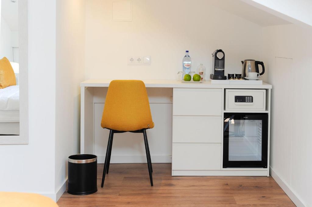 a kitchen with a desk and a yellow chair at Boutique Room Montijo in Montijo