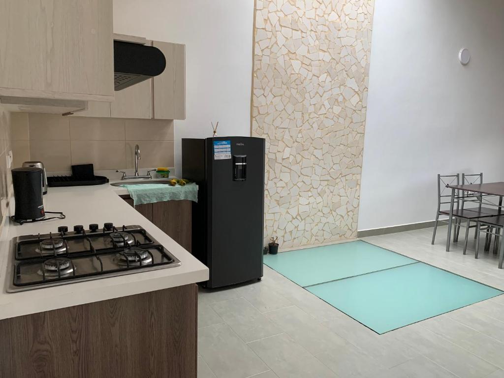 a kitchen with a black refrigerator and a stove at Montesco in Jardin