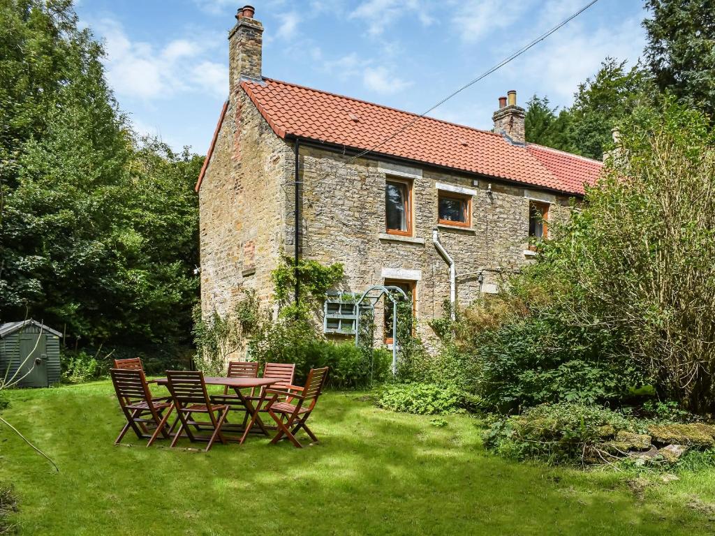 a table and chairs in front of a house at Brookside Cottage in Copley