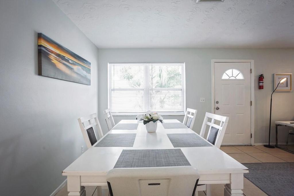 Sunny Shores Retreat 1 في كليرووتر بيتش: غرفة طعام مع طاولة بيضاء وكراسي