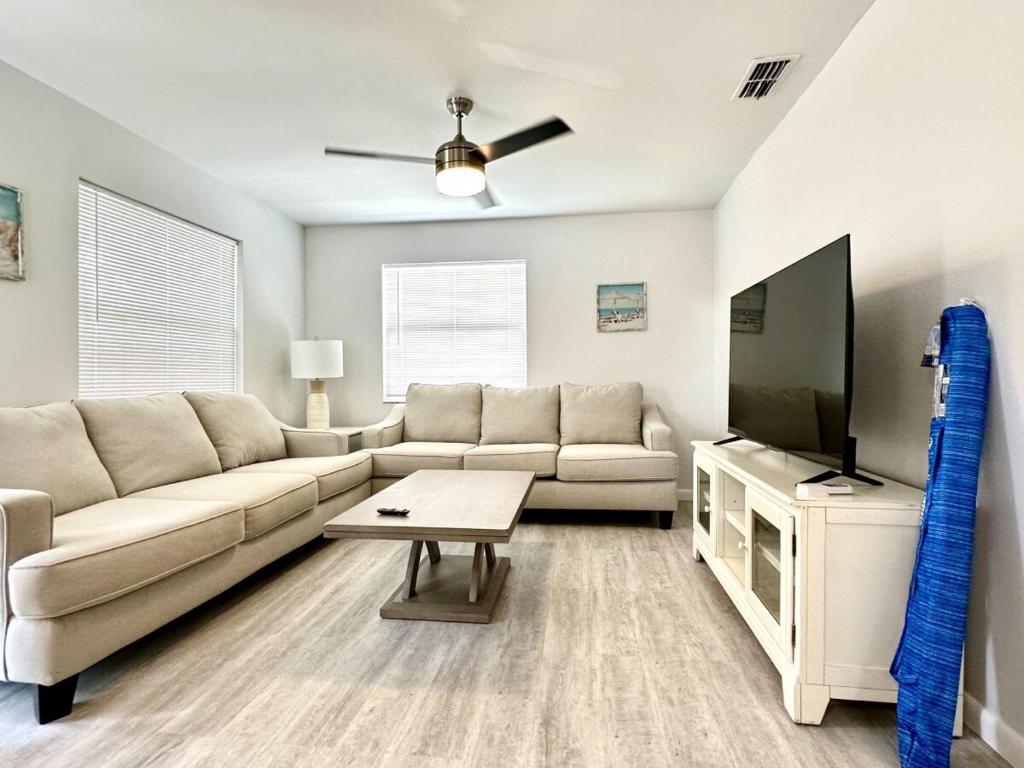 a living room with a couch and a flat screen tv at Sandy Beach Sunset West in Clearwater Beach