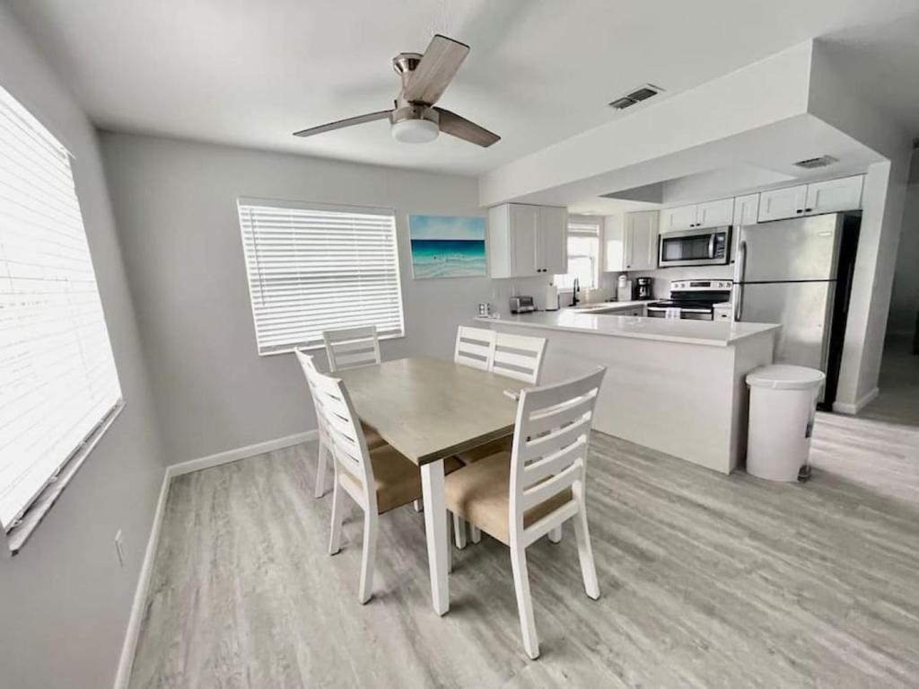 a dining room with a table and chairs in a kitchen at Sandy Beach Sunset East in Clearwater Beach