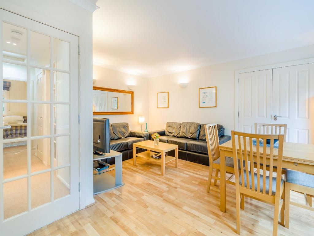 uma sala de estar com um sofá e uma mesa em Burnside West Cottage- Uk39596 em Strathkinness