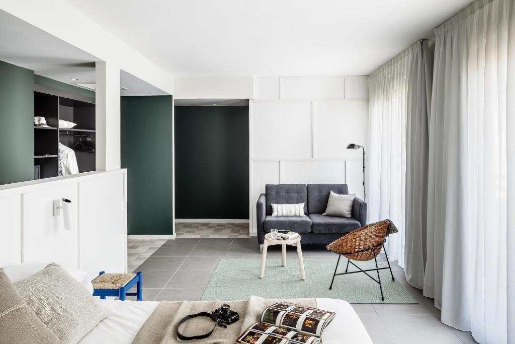 a living room with a couch and a chair at AQUA Hotel Bertran Park in Lloret de Mar