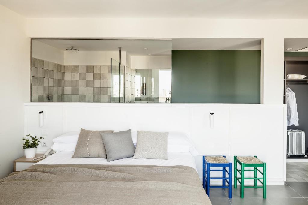 a bedroom with a large bed and two blue stools at AQUA Hotel Bertran Park in Lloret de Mar
