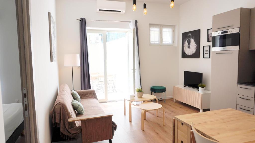 un salon avec un canapé et une table dans l'établissement Centre Cannes, Le Grand Turkheim By Palmazur Vacances, à Cannes