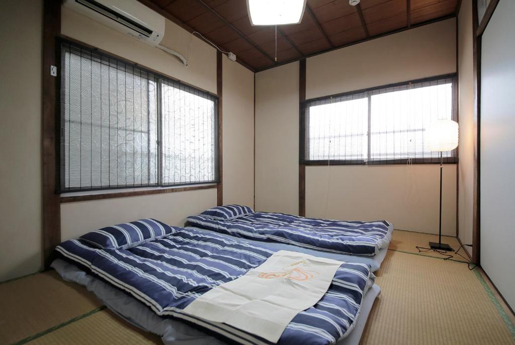 Postel nebo postele na pokoji v ubytování 2F SAKURA RIVER HOUSE, yao 桜と川の家 2F