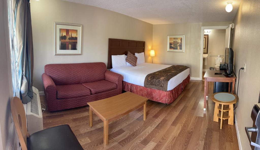 une chambre d'hôtel avec un lit et un canapé dans l'établissement LIBERTY INN, à Kissimmee