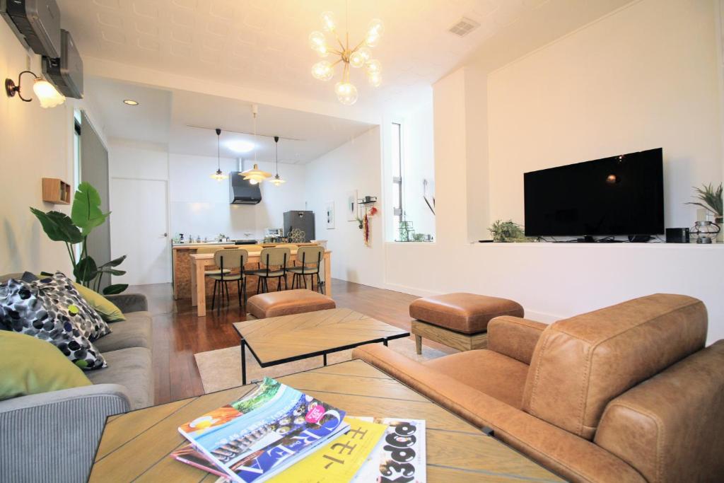 a living room with a couch and a tv at Guest room MINAMI 沖縄 in Okinawa City