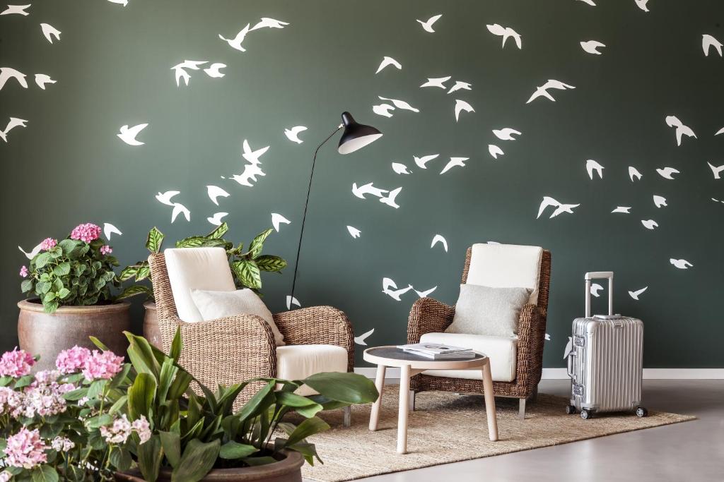 a living room with chairs and birds stenciled on a wall at AQUA Hotel Bertran Park in Lloret de Mar