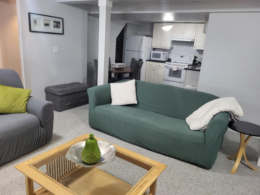 a living room with a green couch and a table at Private basement apartment in Saskatoon