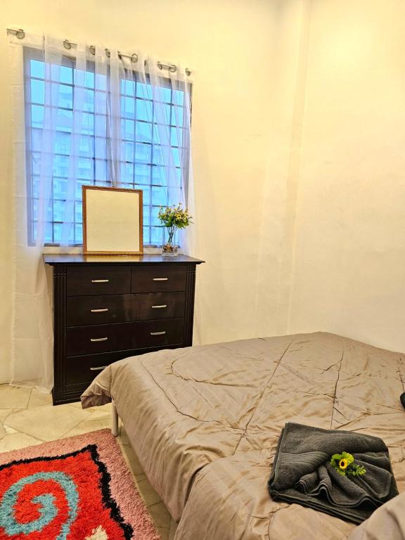 a bedroom with a bed and a dresser and a window at Soul Casa @Gurney Heights Keramat in Kuala Lumpur