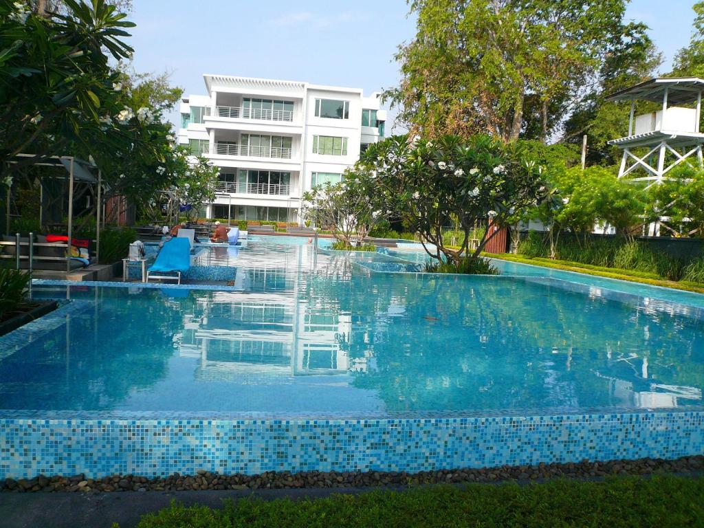 a swimming pool with blue tiles in front of a building at Baan San Dao Hua Hin in Hua Hin