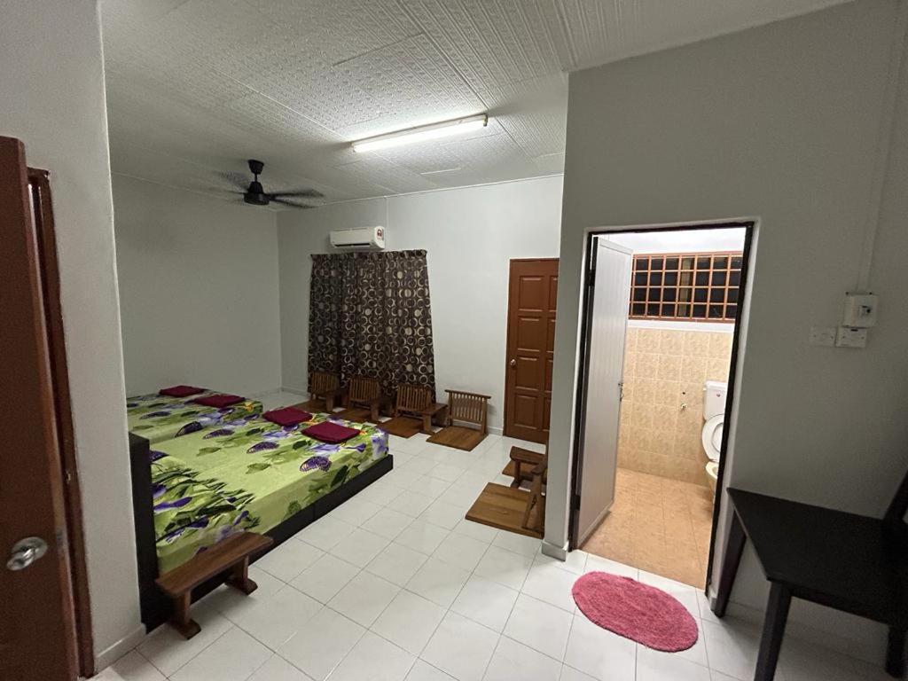 a bedroom with a bed and a bathroom at Muhibbah Homestay in Sungai Siput