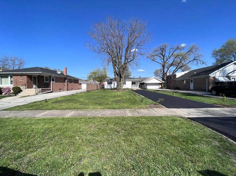a house with a grassy yard in a residential neighborhood at Modern 3Bed 2Bath Ranch with DIY Art Porch 3TVs and Huge Front Yard to Enjoy! in Calumet City