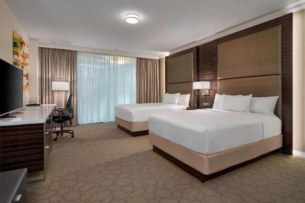 エドモントンにあるデルタ エドモントン センター スイートホテルのベッド2台とテレビが備わるホテルルームです。