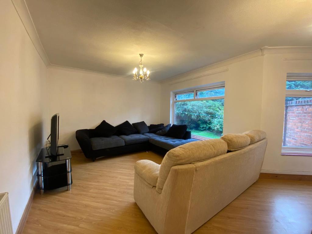 a living room with a couch and a television at Cosy 3BR Home Close to Villa Park Castle Bromwich off the M6 in Birmingham