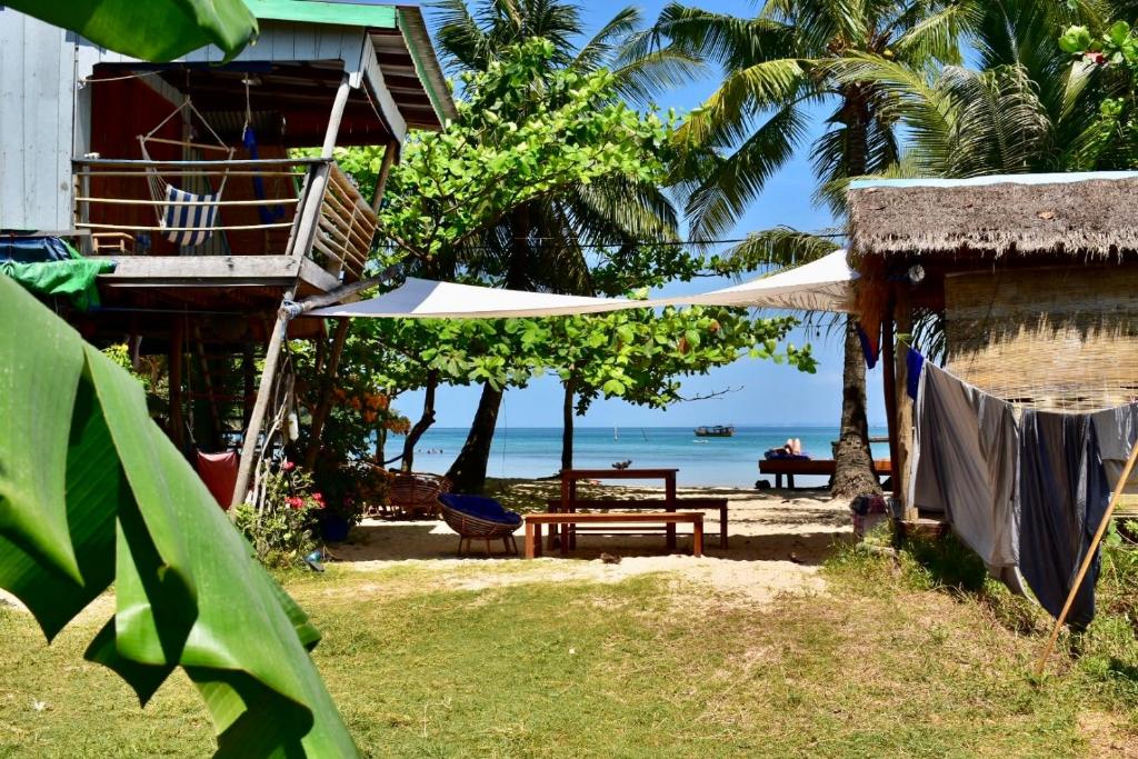 una casa con una mesa y un banco y el océano en Beach House Cambodia, en Koh Rong Sanloem