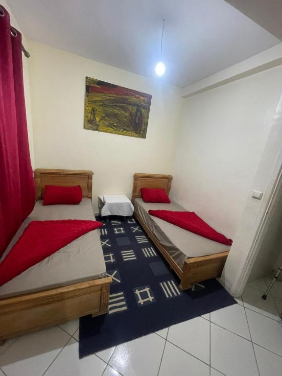 een kamer met 2 bedden in een kamer met een schilderij bij اقامة طريق الخير in Agadir
