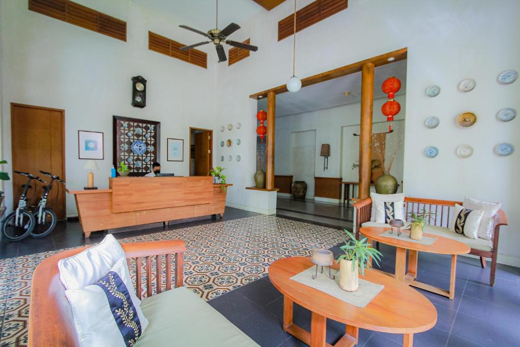 ein Wohnzimmer mit 2 Tischen und einem Sofa in der Unterkunft Billiton Hotel in Tanjungpandan