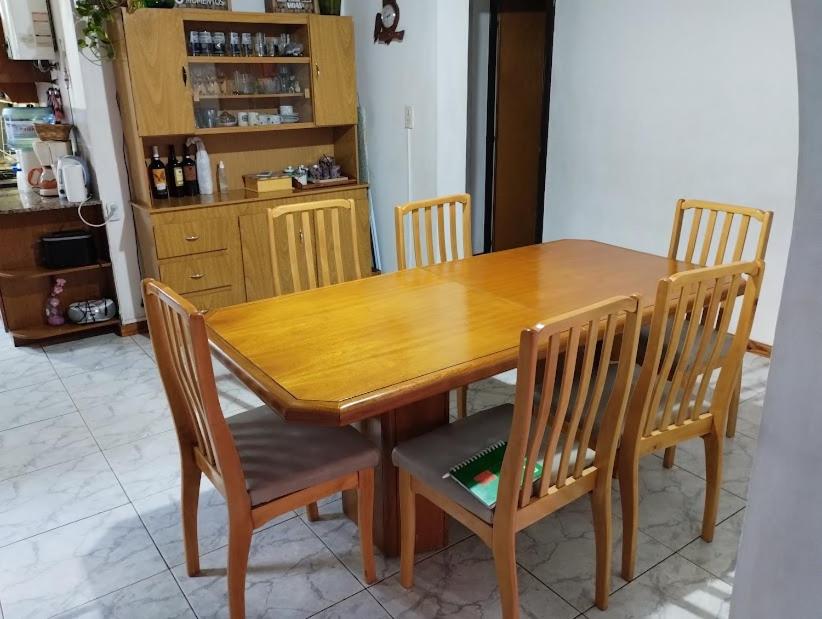 een houten eettafel met 4 stoelen en een tafel bij Casa Plantamura Vacaciones con Familia in La Cieneguita