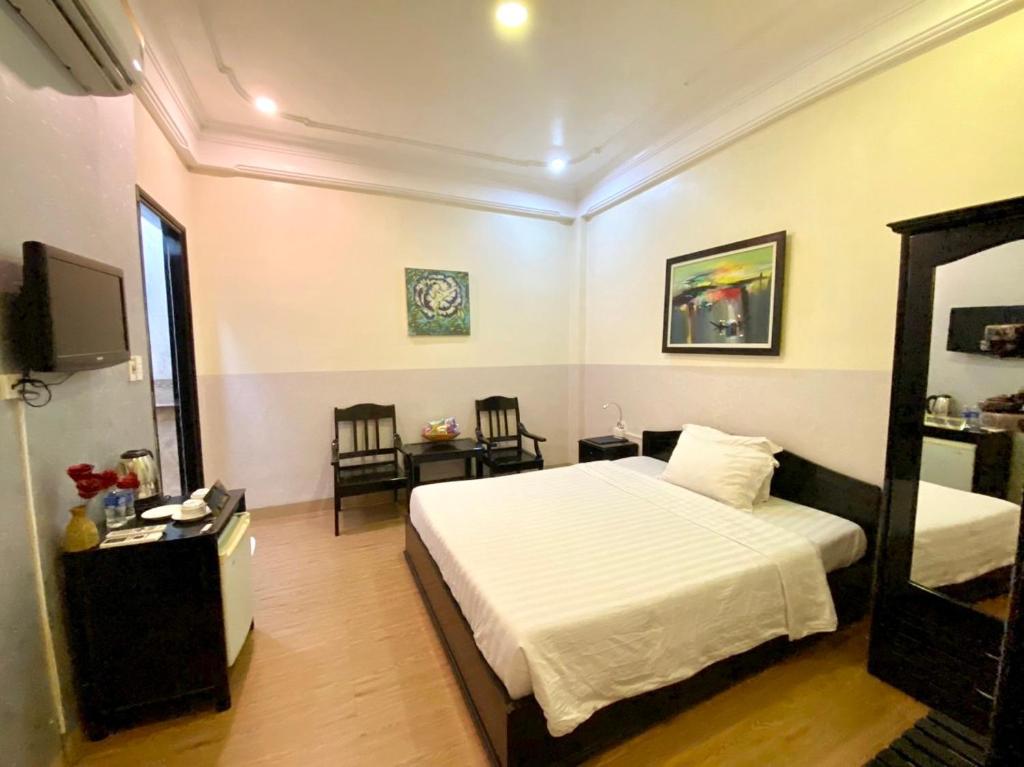 - une chambre avec un lit et une télévision dans l'établissement Jade Hotel, à Hue
