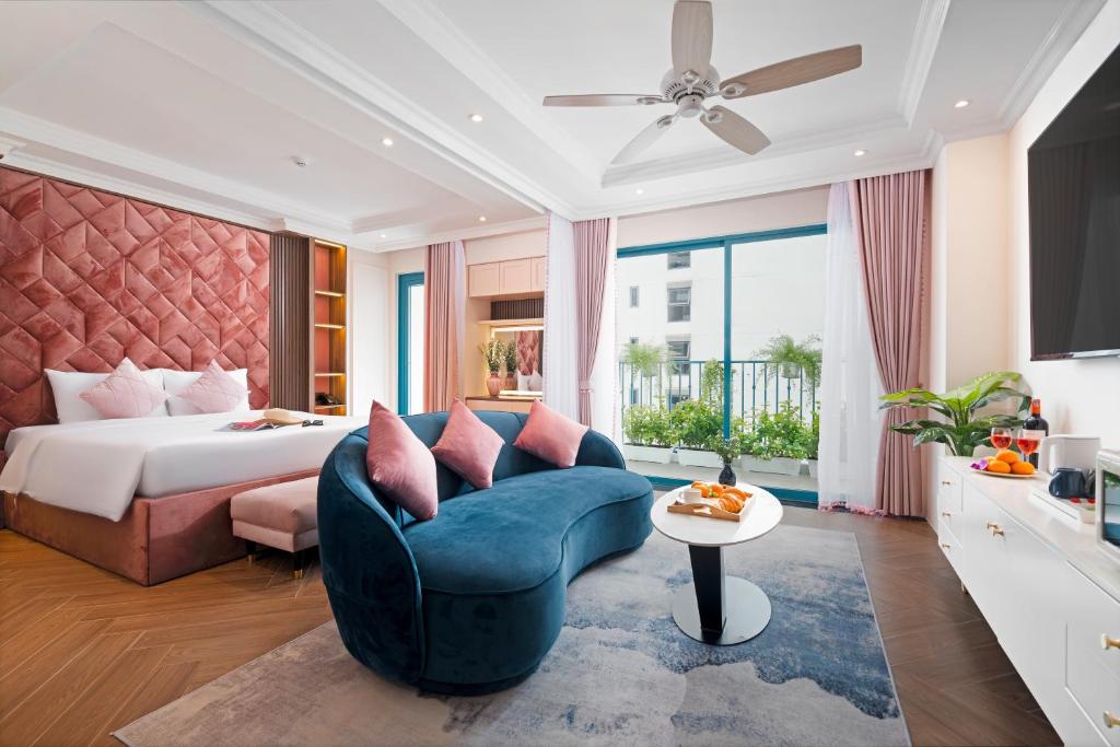 Habitación de hotel con cama y sofá azul en Pavillon Boutique Hotel & Apartment Nha Trang, en Nha Trang