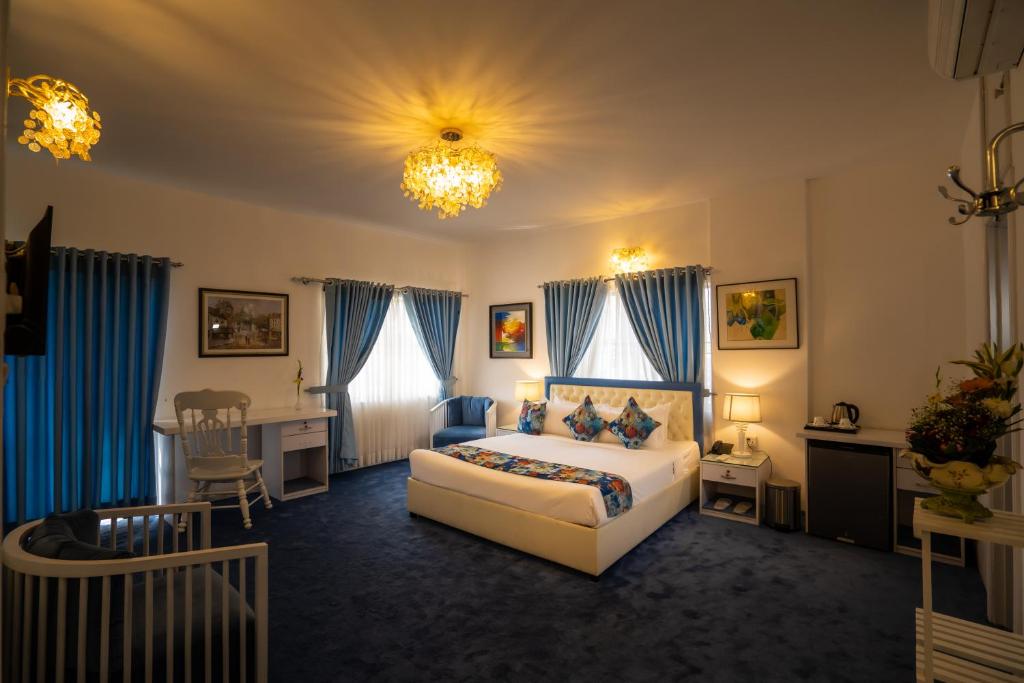 um quarto de hotel com uma cama, uma mesa e cadeiras em Shinepukur Suites at Concord em Daca