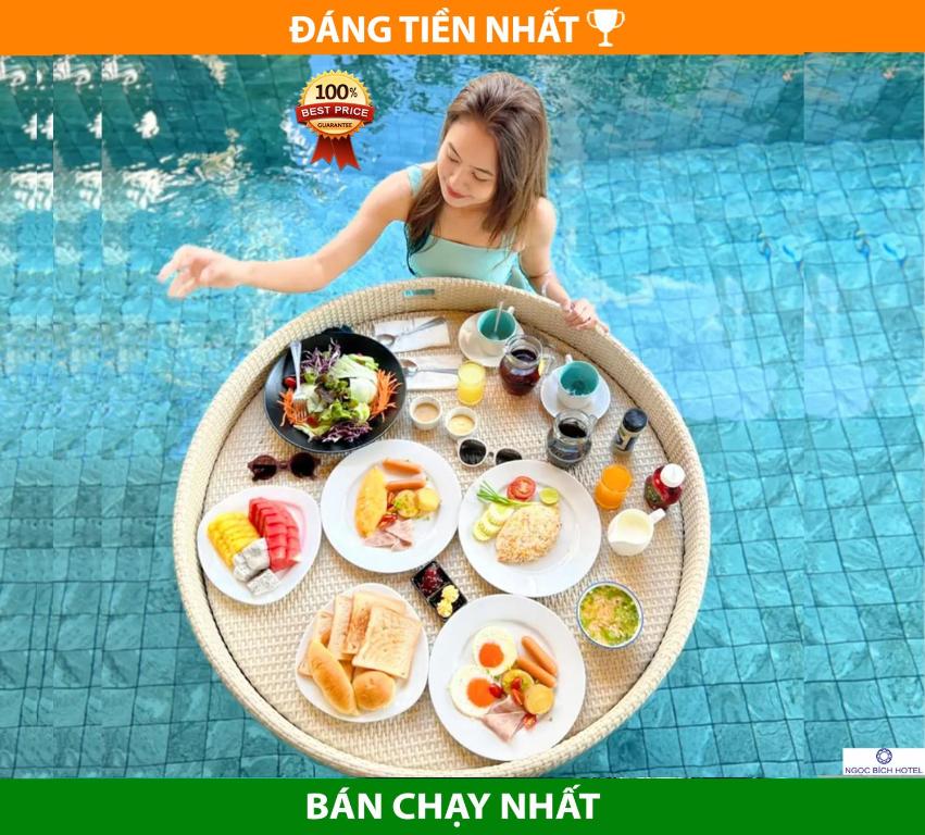 uma jovem sentada numa mesa com comida numa piscina em Ngọc Bích Hotel Da Nang em Da Nang