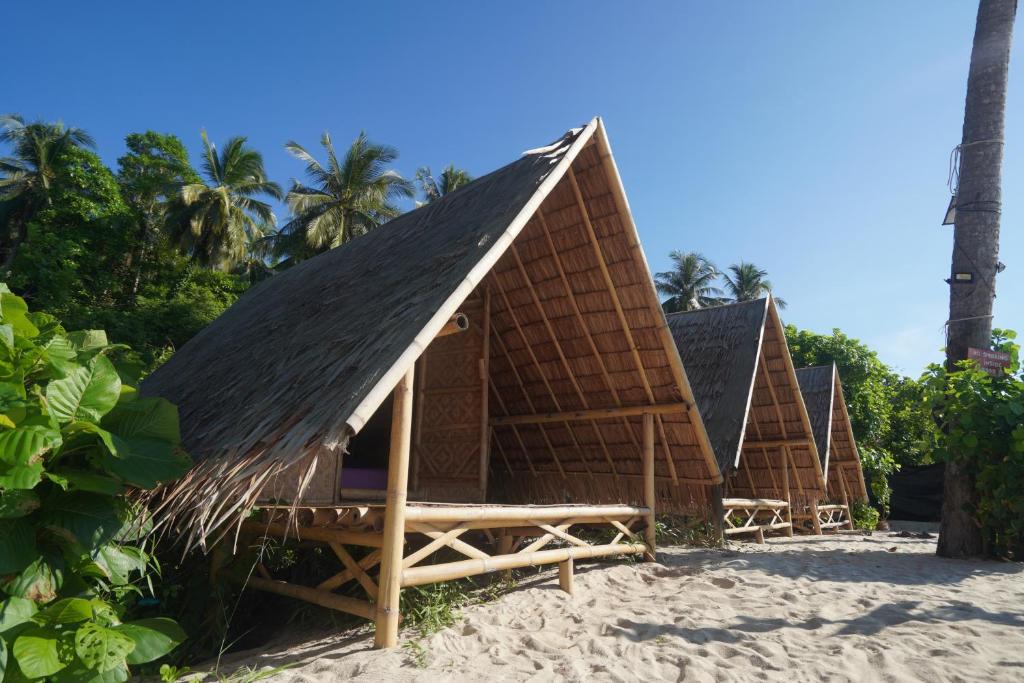 a group of bungalows on the beach at Redang Campstay Bamboo House in Redang Island