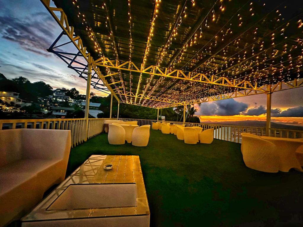 eine Dachterrasse mit einem Tisch, Stühlen und Lampen in der Unterkunft Lucky Tito PG Dive Resort in Puerto Galera