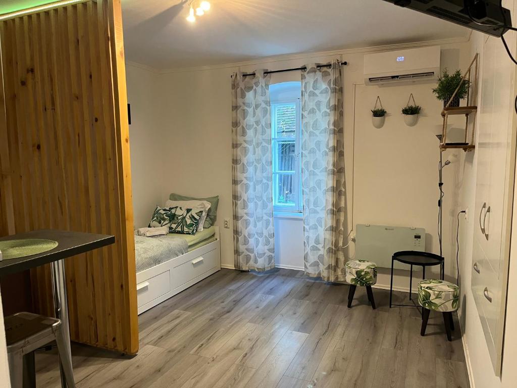 a small bedroom with a bed and a window at Apartman Green in Zagreb