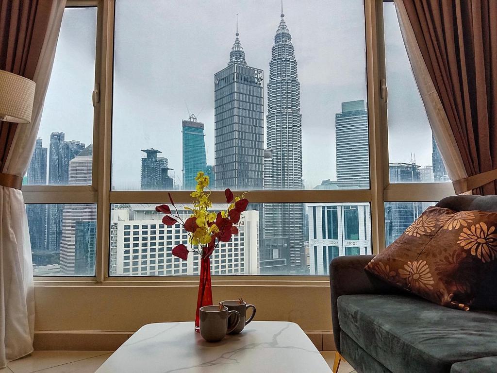 a living room with a view of the city from a window at Habibi HoMe KLCC in Kuala Lumpur