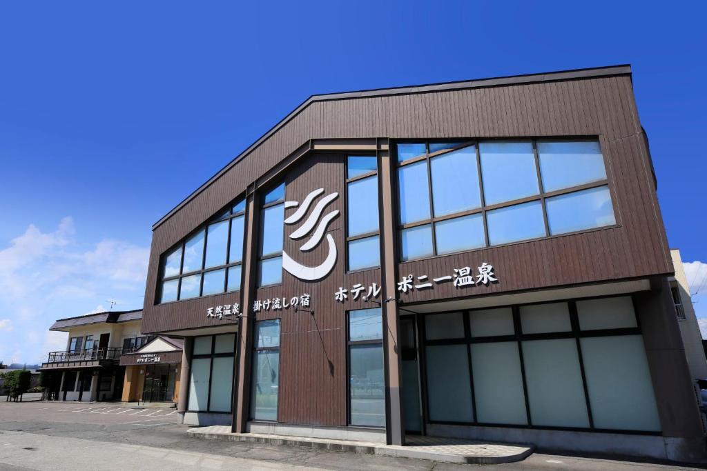 a building with a sign on the side of it at Hotel Pony Onsen in Towada