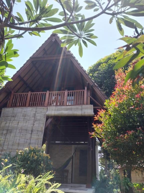 uma casa com uma varanda em cima em triangle cottage bali em Ambengan
