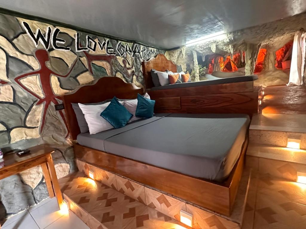 a bed in a room with a rock wall at Gratum Beach Resort in Dapitan
