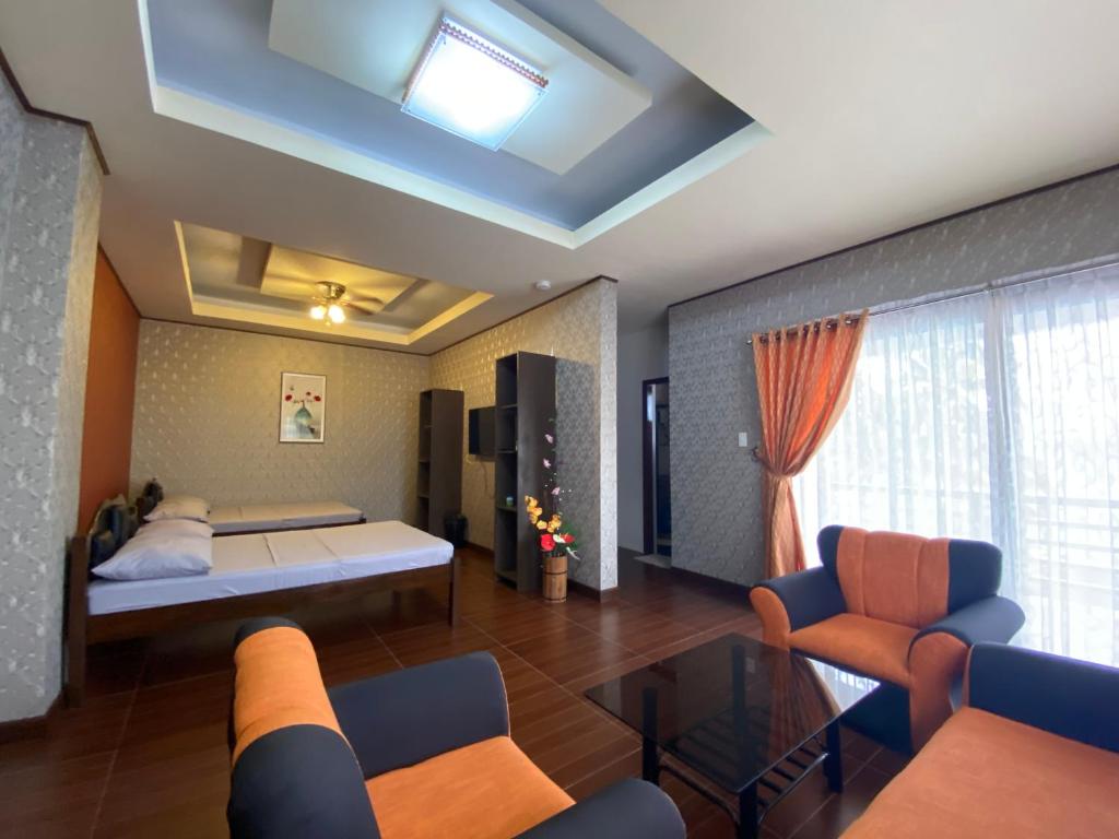 sypialnia z łóżkiem, kanapą i krzesłami w obiekcie MinshukuKCS Hotel and Restaurant w mieście Puerto Galera