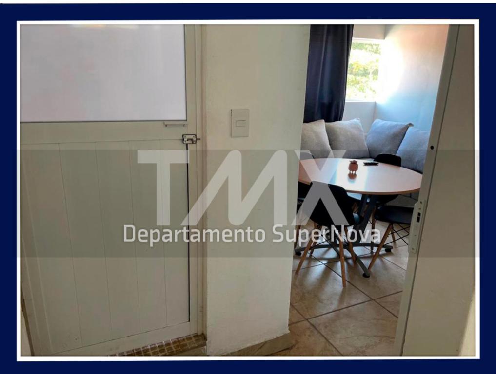 eine Tür, die in ein Wohnzimmer mit einem Tisch führt in der Unterkunft TMX HOSTAL in Puerto Escondido