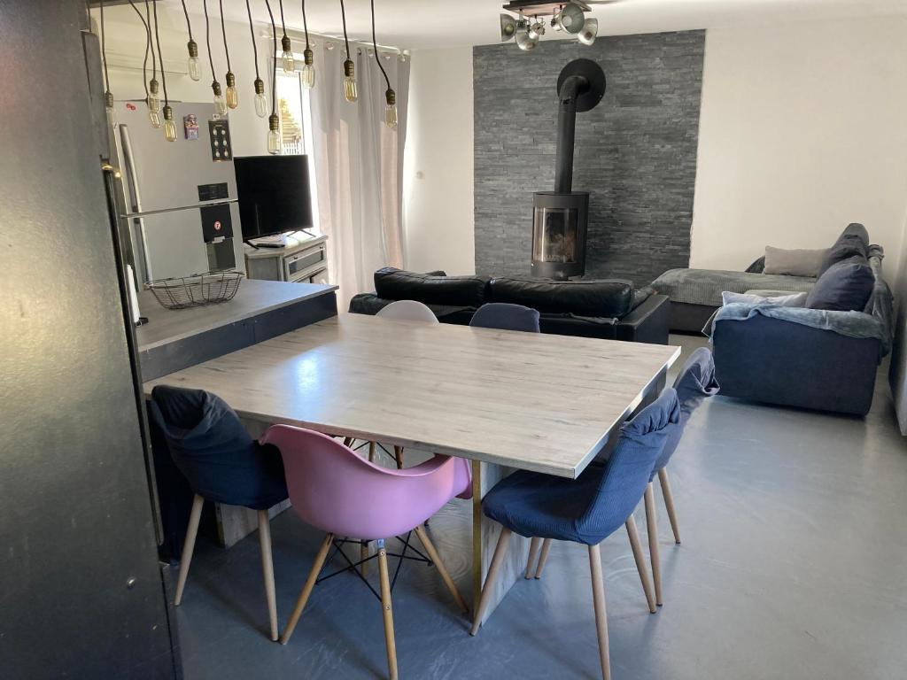 un salon avec une table et des chaises en bois dans l'établissement T3 sur fermette avec les animaux, à Lusigny