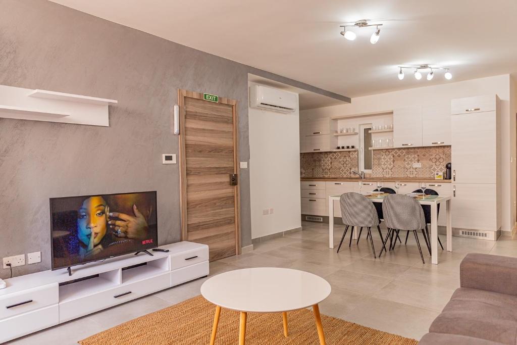 a living room with a couch and a tv and a table at Fancy Modern APT Sliema - w/ 2BR in Sliema