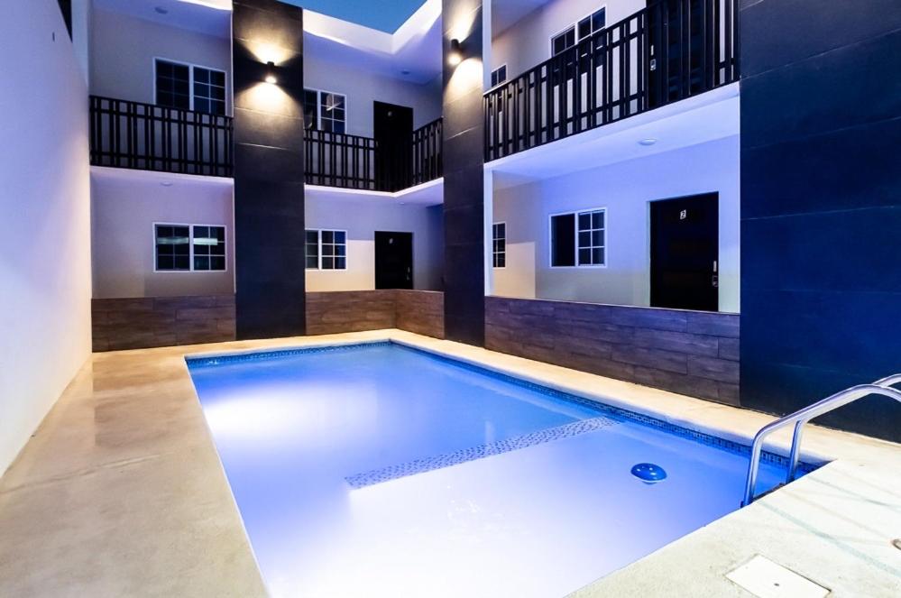 a large swimming pool in a house with a building at Suites González, Suite 2 in Ciudad Juárez