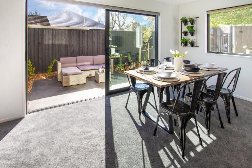 a dining room with a table and chairs at Sunsoaked & Stylish 3 Bed, 1.5 Bath Home w Garage in Christchurch