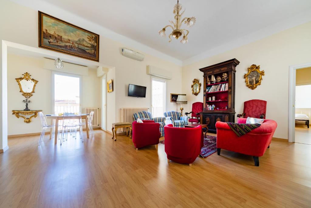 a living room with red chairs and a table at GetTheKey Attico delle Torri in Bologna