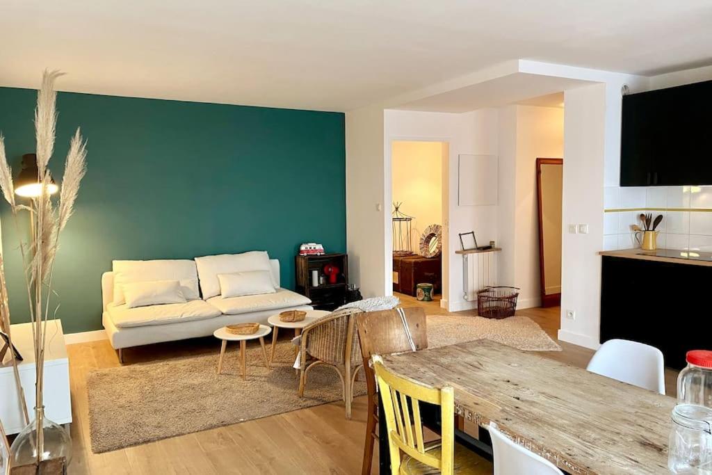 een woonkamer met een bank en een tafel bij Beau 3 pièces cosy avec parking et terrasse in Bordeaux